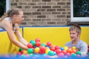 A service user enjoys time in the colourful ball pit